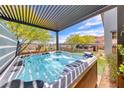 Luxury hot tub under a stylish pergola, overlooking a well-manicured backyard at 109 Reverie Heights Ave, Henderson, NV 89011
