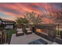 Relaxing backyard with a cozy fireplace, hot tub, and comfortable seating at 109 Reverie Heights Ave, Henderson, NV 89011