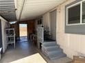 Exterior side patio view of the home with an entry door, steps and painted grey railing with trim at 1305 Shenandoah St, Boulder City, NV 89005