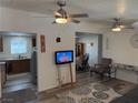 Open concept living room featuring wood-look flooring, ceiling fans and open views to the kitchen and dining area at 1305 Shenandoah St, Boulder City, NV 89005