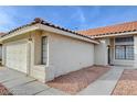 Single-story home with a tile roof, showcasing an attached two-car garage and desert landscaping for low upkeep at 1472 Recital Way, Las Vegas, NV 89119