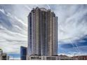 View of modern high-rise building exterior with glass balconies against a bright cloudy sky at 200 W Sahara Ave # 2407, Las Vegas, NV 89102