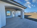 Covered entryway showcasing an arched window and decorative front door with desert views at 2201 W Wisteria Way, Pahrump, NV 89048