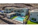 This home's backyard oasis features a pool, lounge area, covered outdoor dining and desert landscaping at 302 Watteau Ct, Henderson, NV 89012