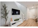 Cozy living room with hardwood floors, media console, and staircase at 3525 Serravalle Ln, Henderson, NV 89044