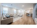 Spacious living room with modern decor, open kitchen, and hardwood floors at 3525 Serravalle Ln, Henderson, NV 89044