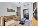 Comfortable living room with brown sofa, balcony access, and a sleek entertainment setup at 5751 E Hacienda Ave # 119, Las Vegas, NV 89122