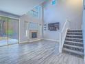 Cozy living area with fireplace, adjacent to a staircase and sliding glass door to the outdoors at 6709 Barrington Hills St, Las Vegas, NV 89149