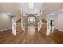 Elegant foyer with a grand curved staircase, hardwood floors, and soaring ceilings at 7460 Grassy Field Ct, Las Vegas, NV 89131