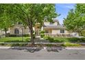 Inviting two-story home with a lush green lawn, mature trees, and a beautifully landscaped front yard at 7460 Grassy Field Ct, Las Vegas, NV 89131