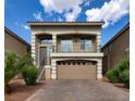 Beautiful two-story home showcasing a front-facing balcony, complemented by a brick driveway and desert landscaping at 8276 Sorrel St, Las Vegas, NV 89139