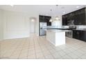 Bright kitchen features a large island, stainless steel appliances, and dark cabinetry in an open-concept design at 8276 Sorrel St, Las Vegas, NV 89139