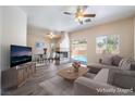 Bright living room with fireplace, ceiling fan, access to the pool and dining area at 844 Binbrook Dr, Henderson, NV 89052