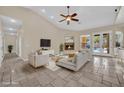 Bright living room with travertine floors, fireplace, and glass doors to outdoor pool at 8945 S Tenaya Way, Las Vegas, NV 89113