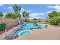 Inviting backyard pool and spa features a rock waterfall, mature landscaping, and desert views at 8945 S Tenaya Way, Las Vegas, NV 89113