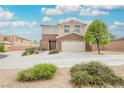 Inviting two-story home with a well-kept lawn, brick accents, and a two-car garage at 9373 Oxbow Lake Ave, Las Vegas, NV 89149