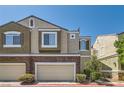 Lovely townhome with a two-car garage, brick accents, neutral stucco exterior, and simple landscaping for curb appeal at 939 Paisley St, Las Vegas, NV 89145
