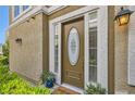 Close-up view of an inviting front door with a decorative oval window, sidelights and potted plants at 939 Paisley St, Las Vegas, NV 89145
