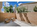 Private patio with seating, brick wall, and lush landscaping offers a serene outdoor living space at 9655 Lame Horse Dr, Las Vegas, NV 89123