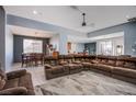Spacious living room featuring tile floors, a ceiling fan, and seamless transition to the dining area at 9831 Running Rabbit St, Las Vegas, NV 89143