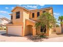 Two-story home featuring a two car garage, neutral stucco, and mature landscaping at 10457 Armand Ave, Las Vegas, NV 89129