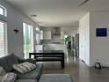 Open-concept living room and kitchen featuring modern finishes, stainless steel appliances, and ample natural light at 10650 Robin Hill Ave, Las Vegas, NV 89129