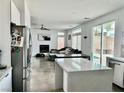 Open-concept living room with modern kitchen island, fireplace, and access to the backyard at 10650 Robin Hill Ave, Las Vegas, NV 89129