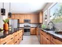 Bright kitchen featuring stainless steel appliances, wood cabinetry, and a black countertop island at 1208 Crimson Sunbird St, North Las Vegas, NV 89084