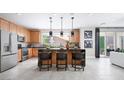 Modern kitchen features wood cabinetry, black countertops, pendant lighting, and stainless steel appliances at 1208 Crimson Sunbird St, North Las Vegas, NV 89084