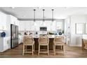 Modern kitchen with white cabinets, stainless steel appliances, an island with bar seating, and pendant lighting at 1212 Crimson Sunbird St, North Las Vegas, NV 89084