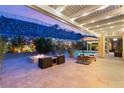 Backyard patio with fire pit, lounge chairs, and an outdoor living space with mountain views at 21 Grand Masters Dr, Las Vegas, NV 89141