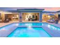 Relaxing backyard pool and lounge area featuring a covered patio and exterior lighting at 21 Grand Masters Dr, Las Vegas, NV 89141