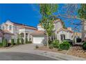 Two-story stucco home with solar panels, landscaped front yard, and a two-car garage at 2212 Warm Walnut Dr, Las Vegas, NV 89134