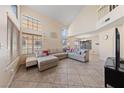 Spacious living room with tile floors, lots of natural light, and comfortable sectional sofa at 2416 Sun Shores Dr, Las Vegas, NV 89128