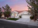 Beautiful nighttime aerial view showcases a landscaped front yard and desert landscaping at 2528 Sunup Dr, Las Vegas, NV 89134