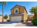 Angle view of home featuring a stucco exterior, desert landscaping, and a convenient two-car garage at 2608 Los Palos St, Las Vegas, NV 89108