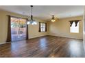 Open-concept living room with wood-look floors, sliding door to patio, and lots of natural light at 2608 Los Palos St, Las Vegas, NV 89108