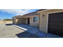 This single-story home has a tile roof and tan stucco exterior with a two-car garage at 3761 S Tumbleweed Ave, Pahrump, NV 89048