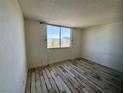 Cozy bedroom featuring wood-look floors and a large window offering plenty of natural light at 3930 University Center Dr # 409, Las Vegas, NV 89119