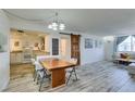 Open-concept living area features whitewashed floors, a dining area, and bright natural light at 3930 University Center Dr # 409, Las Vegas, NV 89119