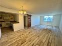 Living room with wood floors, natural light, and an adjacent kitchen featuring stainless steel appliances at 3930 University Center Dr # 409, Las Vegas, NV 89119