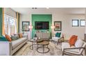 Cozy living room featuring modern furniture, a green accent wall and ample natural light at 4754 Bluebird Cliffs Ave Dr # Lot 170, Las Vegas, NV 89141