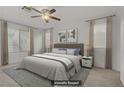 Serene bedroom featuring a king-sized bed, ceiling fan, and ample natural light from large windows at 4972 Groveland Ave, Las Vegas, NV 89139