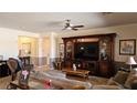 A cozy living room with a ceiling fan and a large entertainment center at 5772 Flying Birdie Ave, Las Vegas, NV 89122
