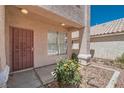 Home's charming front entrance features decorative security door and mature yellow rose bush at 5921 Royal Castle Ln, Las Vegas, NV 89130