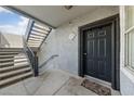 Exterior view of a condo unit entrance with a black door, stairs, and textured wall at 6955 N Durango Dr # 2031, Las Vegas, NV 89149