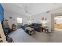 Cozy living room with a comfortable couch, ceiling fan, and access to a balcony at 6955 N Durango Dr # 2031, Las Vegas, NV 89149