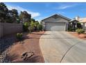 Single-story home showing a paved driveway leading to a two-car garage and simple desert landscaping at 7136 Overhill, Las Vegas, NV 89129