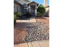 Close-up view of desert landscaping, showing stone beds and plants near the front door and window at 7136 Overhill, Las Vegas, NV 89129