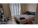 Comfortable bedroom with a large window for natural light, neutral colors, and tile floors at 7155 S Durango Dr # 205, Las Vegas, NV 89113